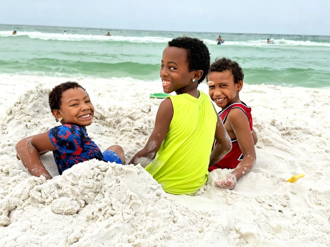 The three Just Josh boys playing together on the beach